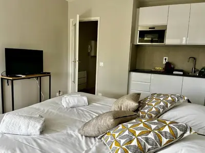 a bedroom with a white bed with pillows on it at La douceur de vivre à Cannes in Cannes