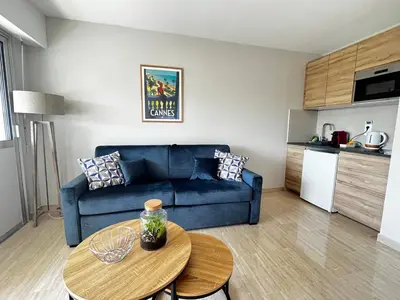 a living room with a blue couch and a table at La douceur de vivre à Cannes in Cannes