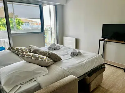 a bedroom with a bed with pillows and a television at La douceur de vivre à Cannes in Cannes