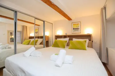 a bedroom with a large white bed with green pillows at IMMOGROOM - Beautiful Duplex - 5 min from the beach - AC - SUQUET in Cannes