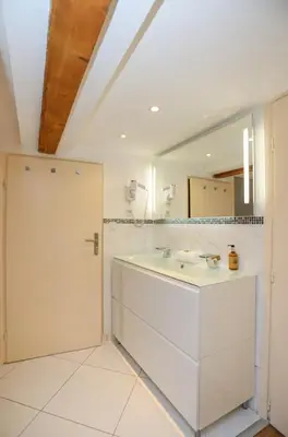 a bathroom with a sink and a mirror at IMMOGROOM - Beautiful Duplex - 5 min from the beach - AC - SUQUET in Cannes