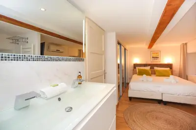 a bathroom with a sink and a bed in a room at IMMOGROOM - Beautiful Duplex - 5 min from the beach - AC - SUQUET in Cannes