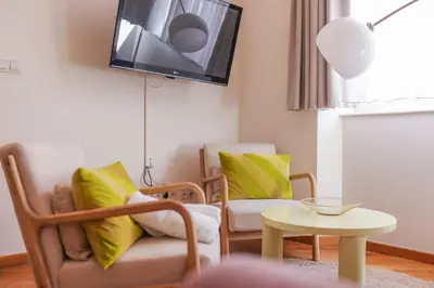 a living room with two chairs and a tv on the wall at IMMOGROOM - Beautiful Duplex - 5 min from the beach - AC - SUQUET in Cannes