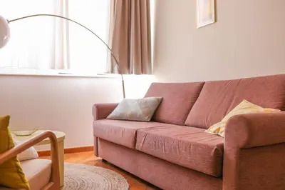 a living room with a pink couch and a chair at IMMOGROOM - Beautiful Duplex - 5 min from the beach - AC - SUQUET in Cannes