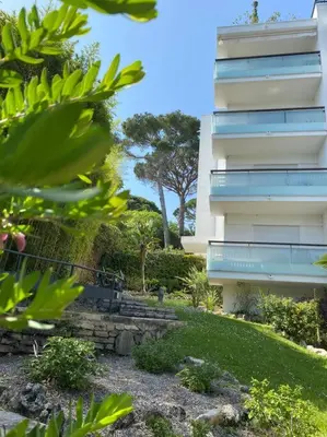 a tall building with a yard and a building at Joli studio calme et central in Cannes