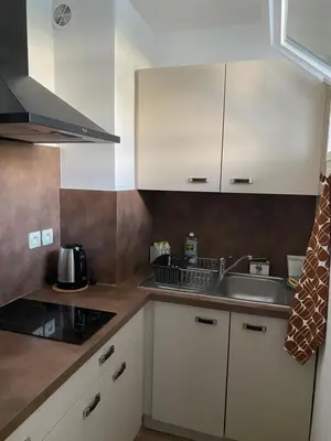 a kitchen with white cabinets and a sink at Joli studio calme et central in Cannes