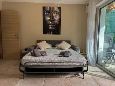a bedroom with a bed with a picture on the wall at COSY MADRID, appartement proche de la mer in Cannes