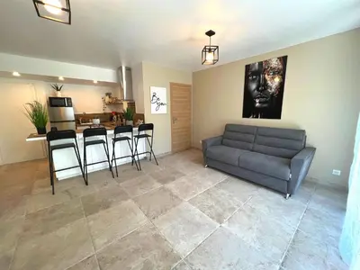a living room with a couch and a table and chairs at COSY MADRID, appartement proche de la mer in Cannes