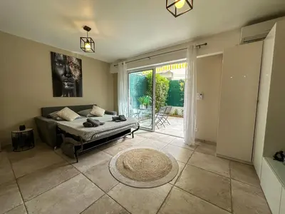 a bedroom with a bed and a large window at COSY MADRID, appartement proche de la mer in Cannes