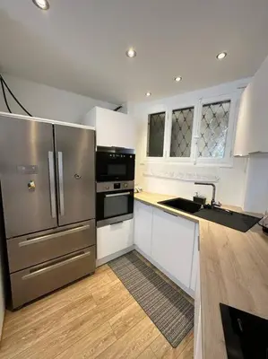 a kitchen with stainless steel appliances and white cabinets at Cannes : Appartement rénové proche plage in Cannes
