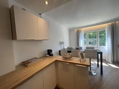 a kitchen with a counter with chairs and a table at Cannes : Appartement rénové proche plage in Cannes