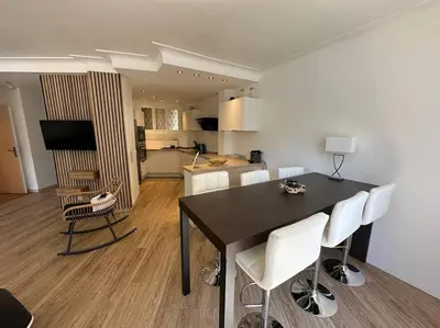 a dining room with a table and white chairs at Cannes : Appartement rénové proche plage in Cannes