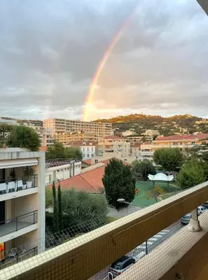 a rainbow in the sky over a city at Appartement cannes Croisette in Cannes