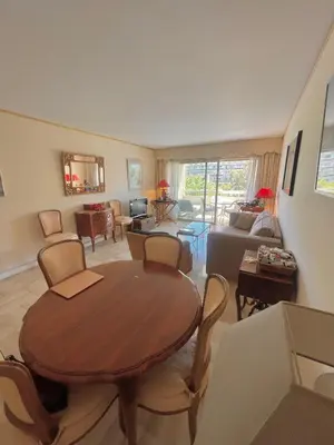 a living room with a wooden table and chairs at Appartement cannes Croisette in Cannes