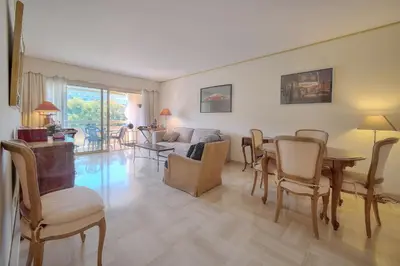 a living room with a table and chairs at Appartement cannes Croisette in Cannes