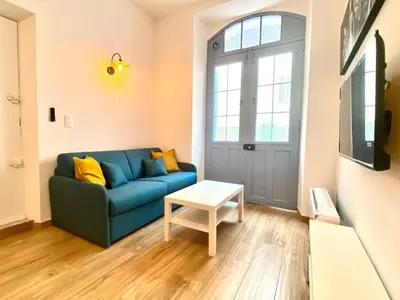 a living room with a blue couch and a table at Le Perrissol By SCLS Locations in Cannes