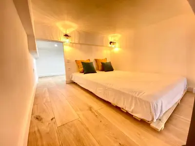 a bedroom with a bed and a wooden floor at Le Perrissol By SCLS Locations in Cannes
