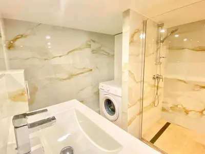 a bathroom with a sink and a washing machine at Le Perrissol By SCLS Locations in Cannes