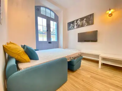 a room with a bed and a couch and a tv at Le Perrissol By SCLS Locations in Cannes