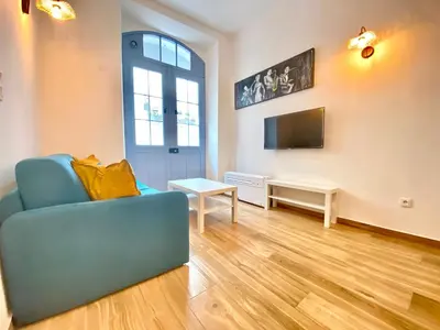 a living room with a blue couch and a tv at Le Perrissol By SCLS Locations in Cannes
