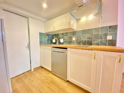 a kitchen with white cabinets and a counter top at Le Perrissol By SCLS Locations in Cannes