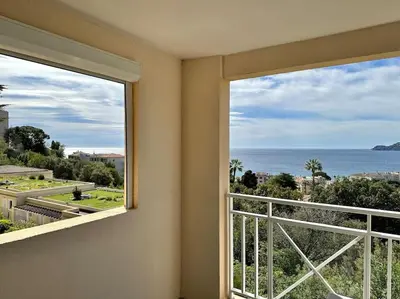 a room with a balcony with a view of the ocean at Beau T2 avec terrasse vue mer in Cannes