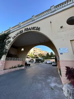 a bridge over a parking lot with a person walking under it at Beau T2 avec terrasse vue mer in Cannes