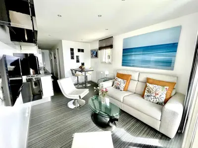 a living room with a couch and a table at Beau T2 avec terrasse vue mer in Cannes