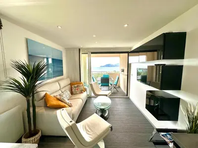 a living room with a couch and chairs and a television at Beau T2 avec terrasse vue mer in Cannes