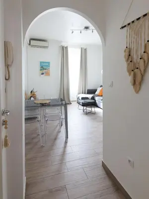 a living room with a table and a dining room at Luciana Cannes avec parking - proximité centre croisette -gare -plage in Cannes