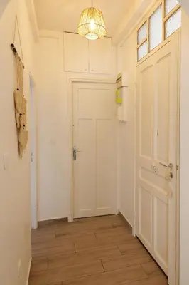 a hallway with a white door and a chandelier at Luciana Cannes avec parking - proximité centre croisette -gare -plage in Cannes