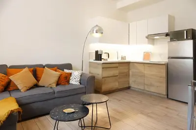 a living room with a couch and a kitchen at Luciana Cannes avec parking - proximité centre croisette -gare -plage in Cannes