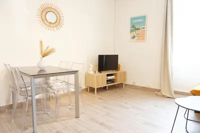 a living room with a table and a tv at Luciana Cannes avec parking - proximité centre croisette -gare -plage in Cannes