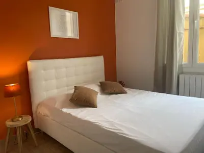 a bed with two pillows on it in a bedroom at Luciana Cannes avec parking - proximité centre croisette -gare -plage in Cannes