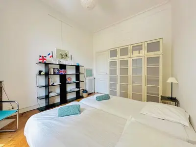 a bedroom with a large bed and a fireplace at L'Imperial - Magnifique Appartement Cannes 5 chambres in Cannes
