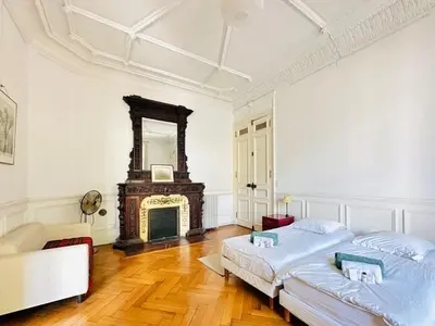 two beds in a white room with a fireplace at L'Imperial - Magnifique Appartement Cannes 5 chambres in Cannes