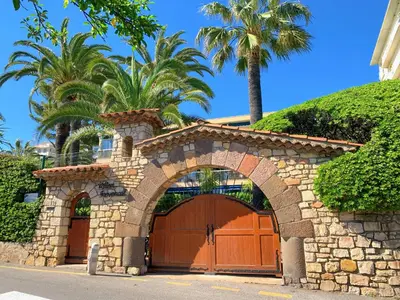 a garage with a stone gate and palm trees at Studio front de mer, 30M2 Piscine & Mer in Cannes