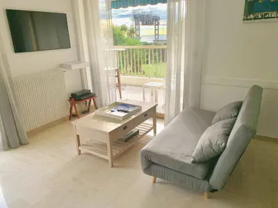 a living room with a couch and a coffee table at Appartement front de mer, 80M2 (3P), Piscine & Mer in Cannes