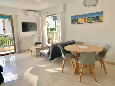 a living room with a table and chairs at Appartement front de mer, 80M2 (3P), Piscine & Mer in Cannes