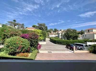 a view of a residential street with flowers and cars at Appartement Beauvallon in Cannes