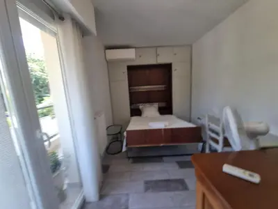a small bedroom with a bed and a window at Appartement Beauvallon in Cannes