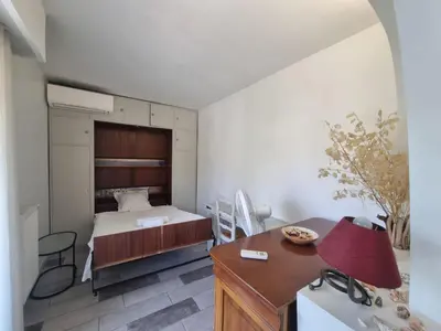 a bedroom with a bed and a desk with a red lamp at Appartement Beauvallon in Cannes