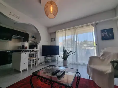 a living room with a coffee table and a television at Appartement Beauvallon in Cannes