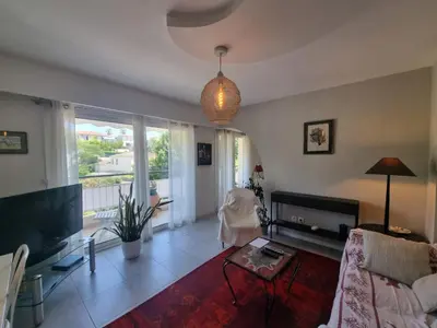 a living room with a couch and a tv at Appartement Beauvallon in Cannes