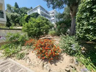 a garden with flowers in front of a building at Appartement Beauvallon in Cannes