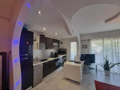 a kitchen with black and white appliances and a table at Appartement Beauvallon in Cannes