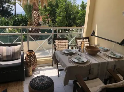 a patio with a table and chairs on a balcony at Quiet sea view with pool in Cannes