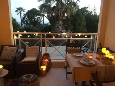 a patio with a table and chairs and a balcony at Quiet sea view with pool in Cannes