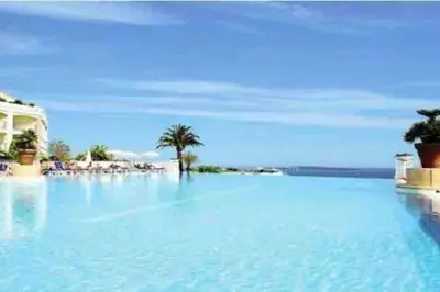 a large pool of blue water next to a beach at Quiet sea view with pool in Cannes