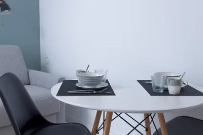a white table with two plates and cups on it at LE MIMONT studio central et calme, séjours en couple ou congrès in Cannes